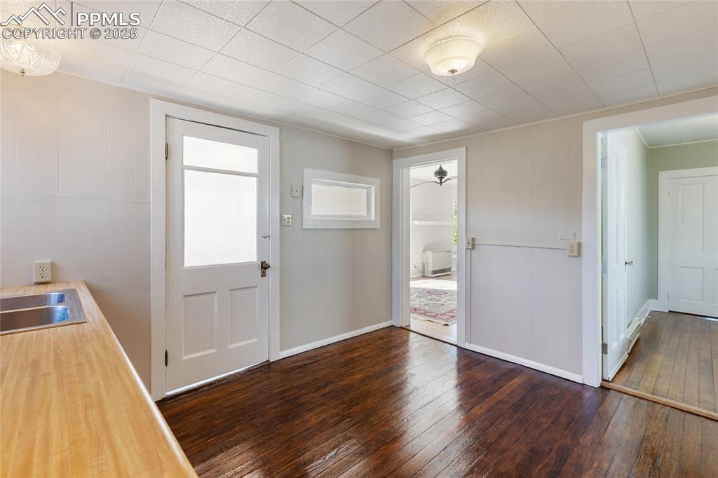 Foyer with dark wood-style floors and baseboards