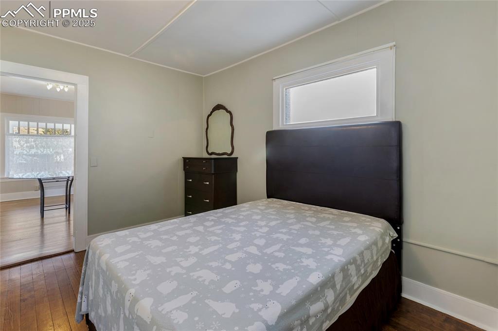 Bedroom featuring dark wood-style flooring and multiple windows