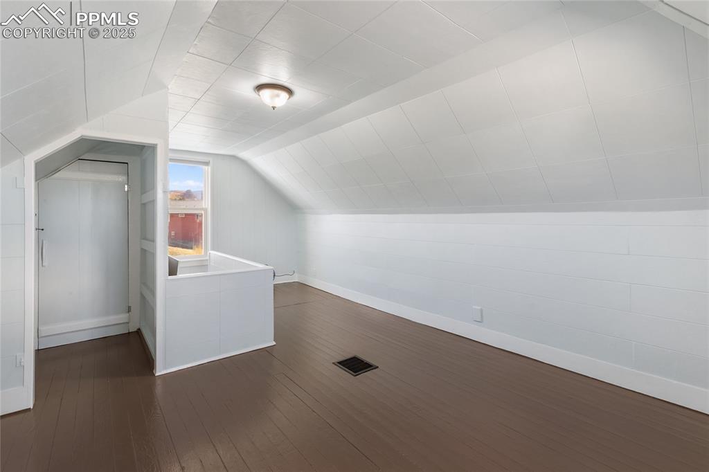 Bonus room featuring lofted ceiling and dark wood-style flooring