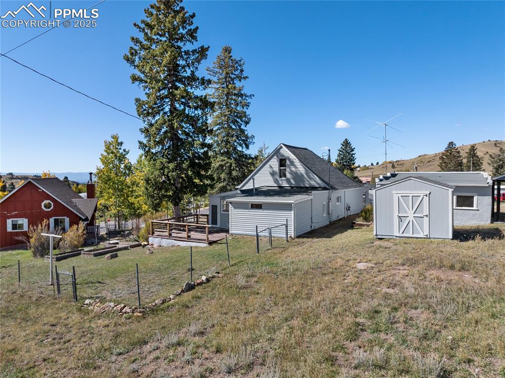 View of yard with a storage shed, a garden, and a deck with mountain view