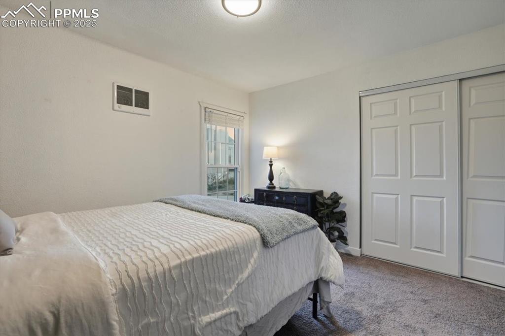 Carpeted bedroom with a closet and a textured ceiling
