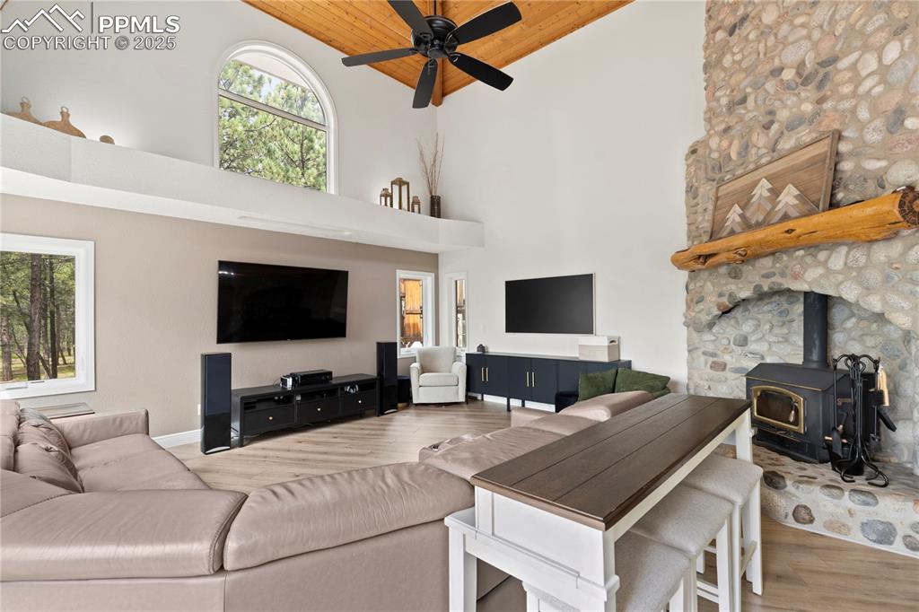 The living room features vaulted ceilings, a fireplace, ceiling fans and luxury vinyl flooring