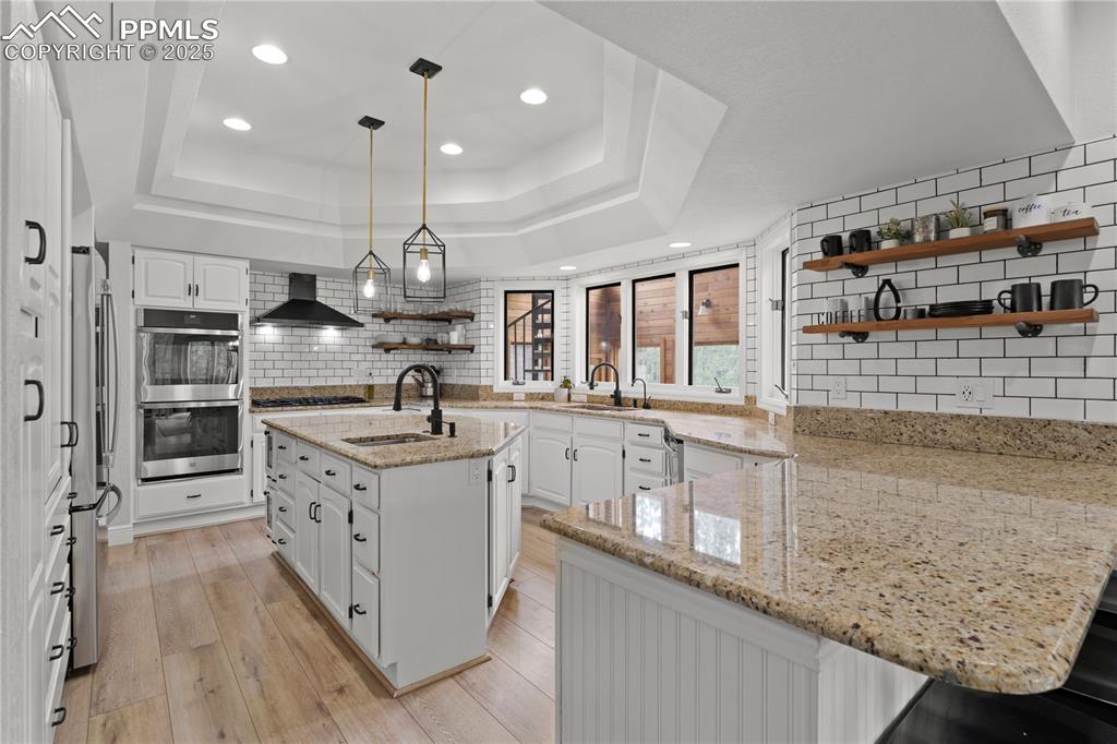 The kitchen features pendant lighting, ample storage and prep space, double ovens and new appliances