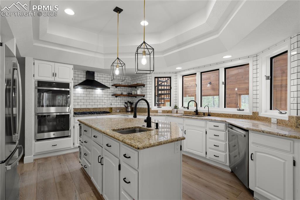 This kirchen feautires granite counters, double ovens and new appliances along with a bar area and beverage fridge. 