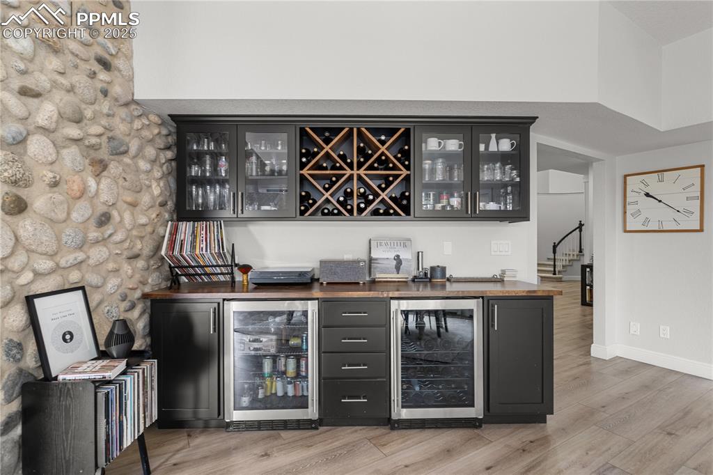 The bar near the kitchen has the warm of the stone wall with the convenience of a beverage refrigerator