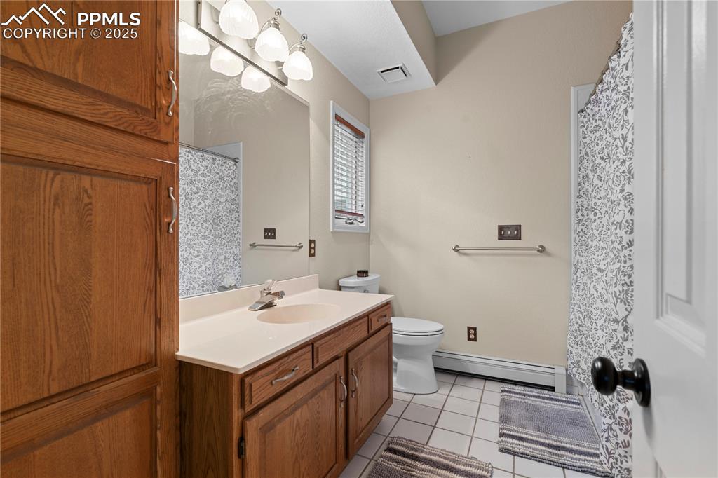 Full bathroom with ample storage and stone counters