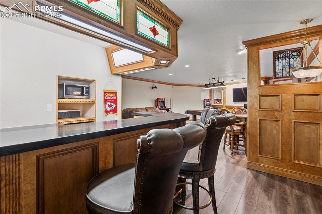 Basement bar area with custom woodwork and stone counters