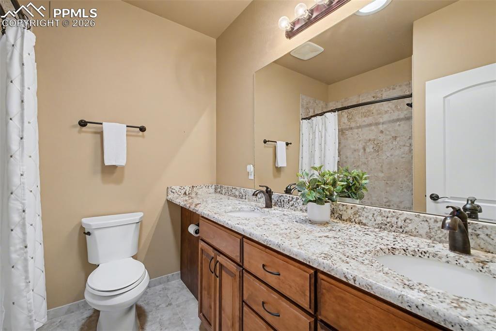 Main level full bathroom with double vanity and granite countertops