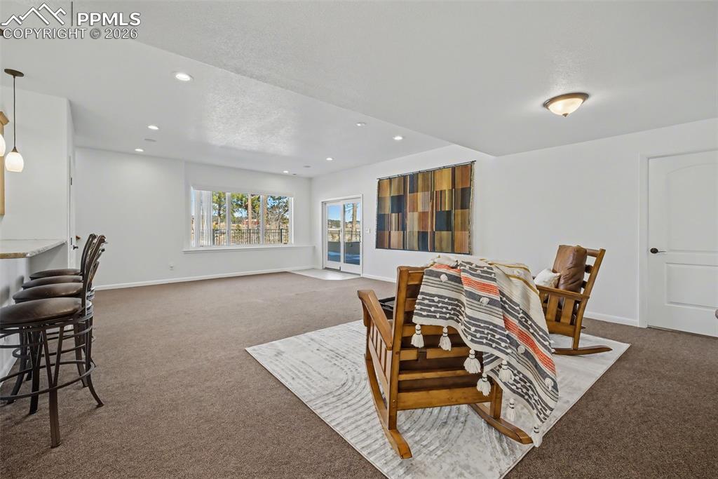 Basement family room with garden level window and access to shaded patio through the walk out and adjacent to the secondary kitchen/wet bar