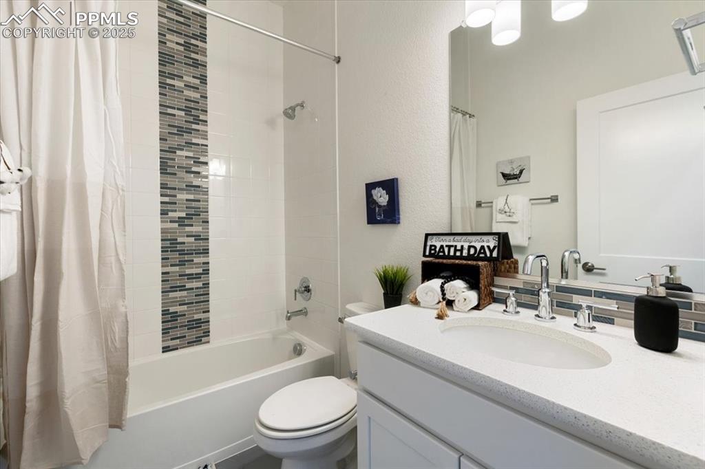 Full bath with toilet, vanity, and shower / bath combo with shower curtain