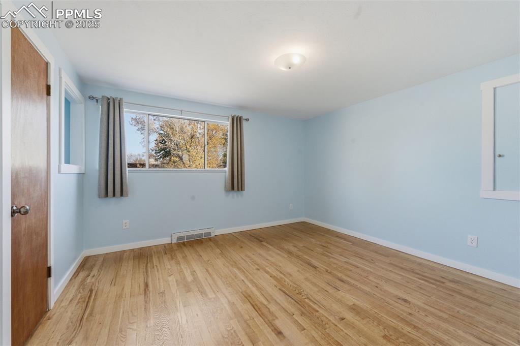 Spare room featuring wood floors and baseboards