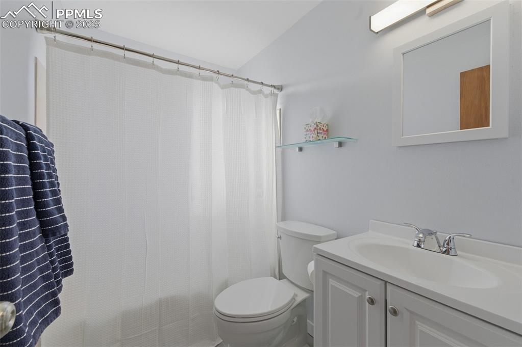 Full bath with vanity, shower / tub combo, and lofted ceiling