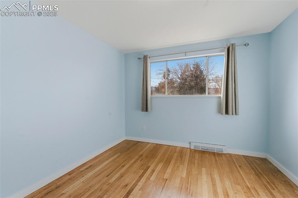 Spare room featuring light wood-style flooring and baseboards