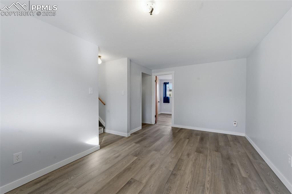Empty room featuring wood finished floors and stairway