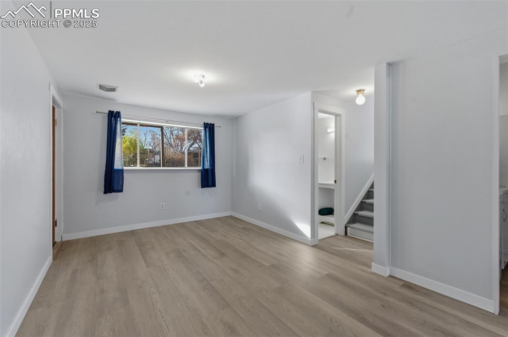 Spare room featuring light wood finished floors and stairs