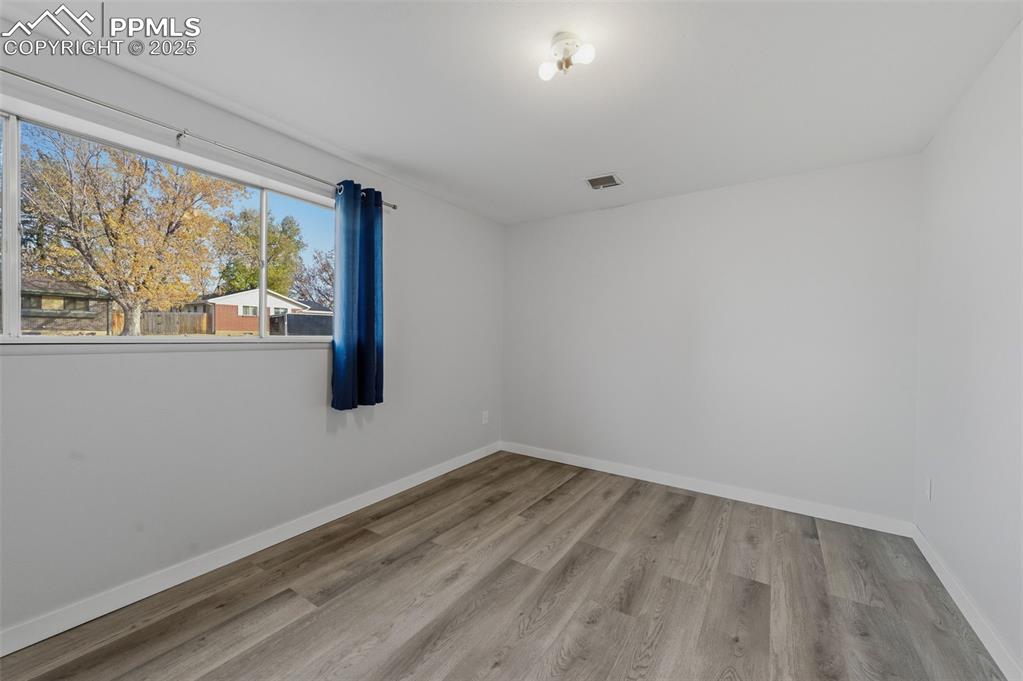 Unfurnished room with baseboards and light wood-style floors
