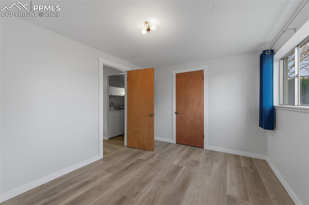 Unfurnished bedroom with light wood-style floors and a closet