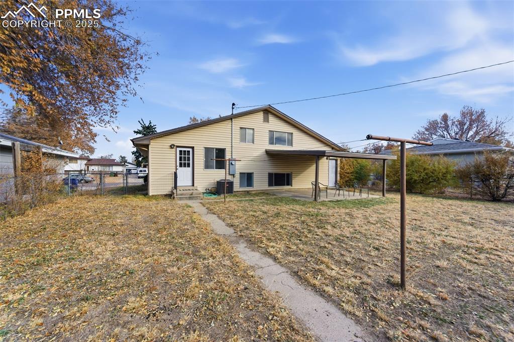 Rear view of property with entry steps, a patio area, and a gate