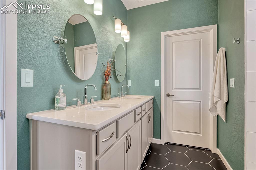 The adjoining master bathroom features tile floors, dual vanities, large walk-in shower and a walk-in closet
