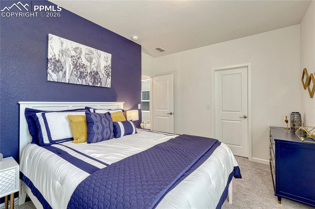 The second upper-level bedroom has a painted accent wall and walk-in closet
