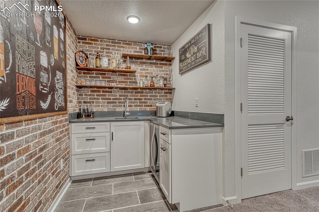 The Chicago-style wet bar features grey quartz countertops and built-in wine/beverage fridge
