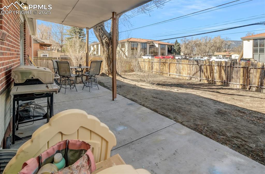 View of patio with a fenced backyard and outdoor dining area
