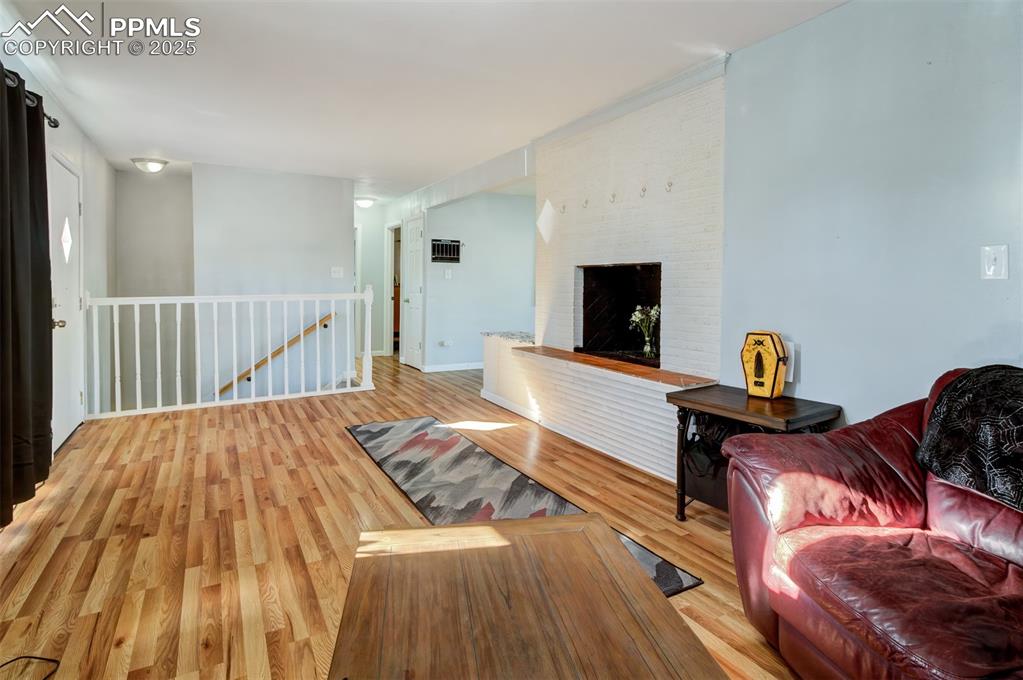 Living room featuring a brick fireplace and light wood-type flooring