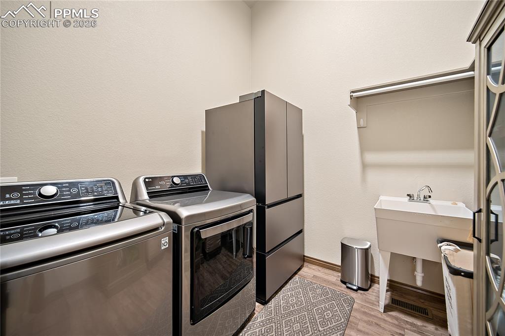 Main level laundry with sink and shelving.