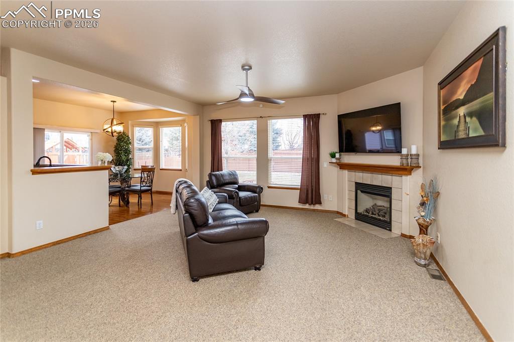 Bright and specious great room has a gas fireplace with a tile surround.