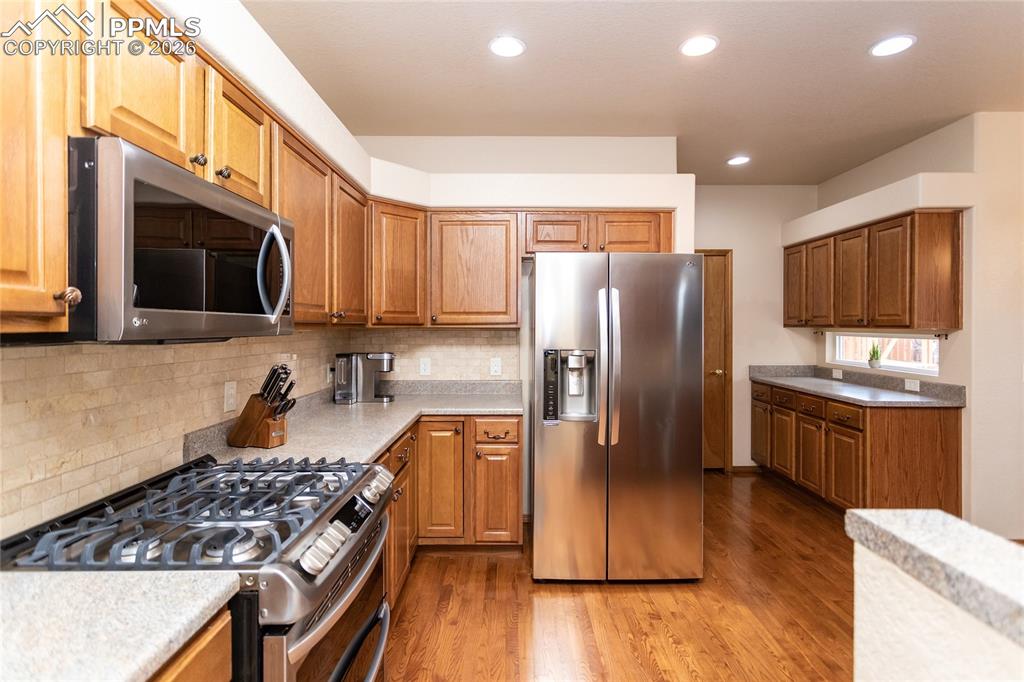 Newer stainless steel appliances include a gas range with double ovens.