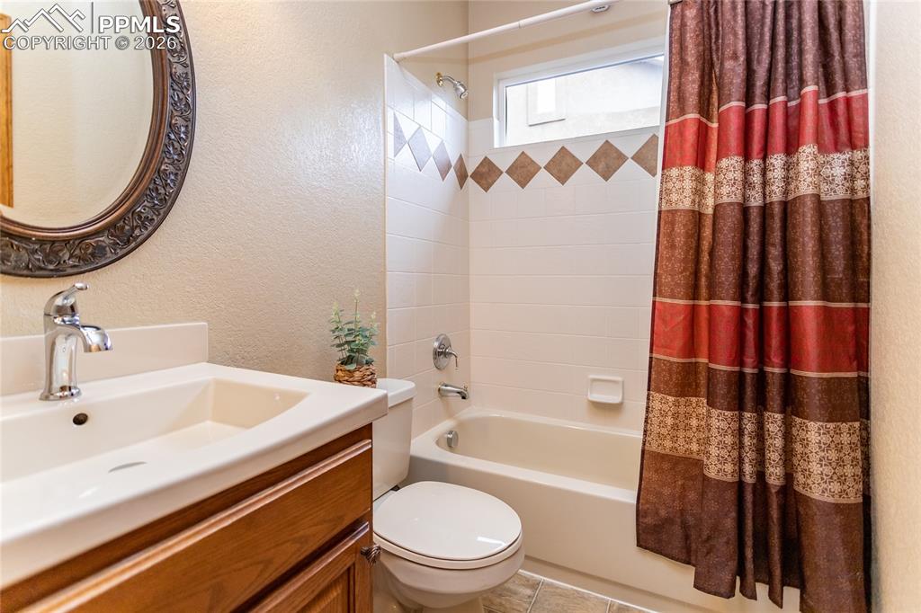 Main level hall bathroom features a newer vanity and mirror and a tub/shower combo with tile surround.