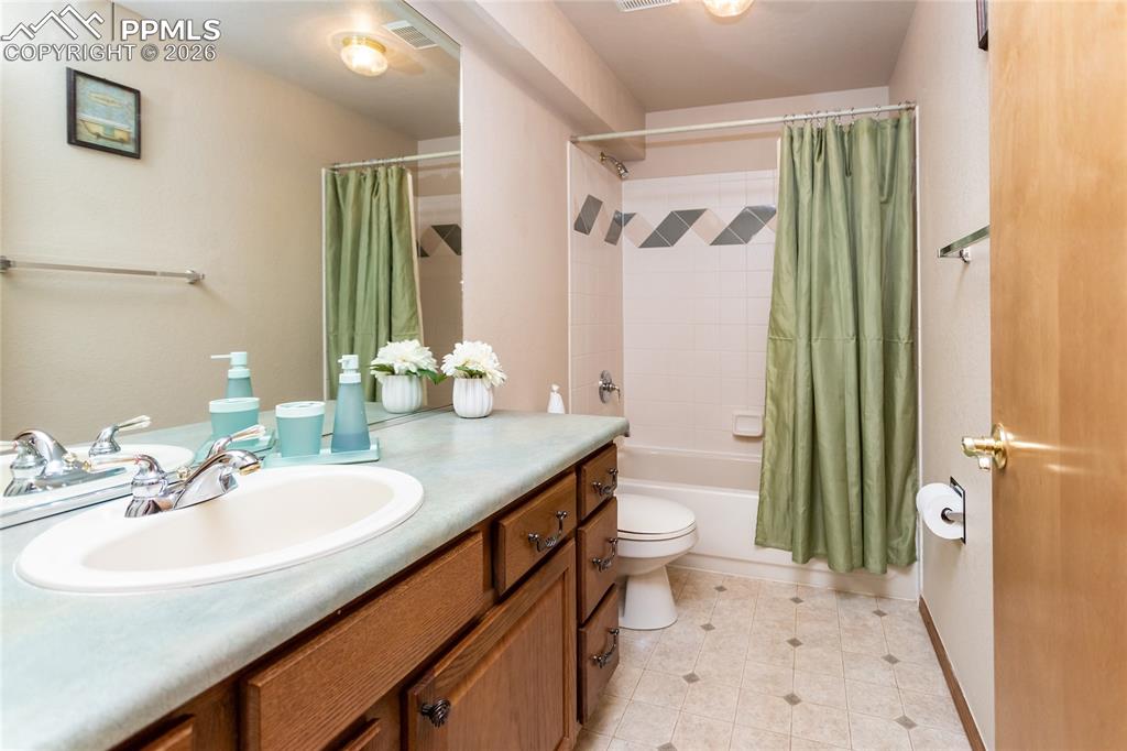 Hall bathroom in the basement has an extended vanity and a tub/shower combo with tile surround.