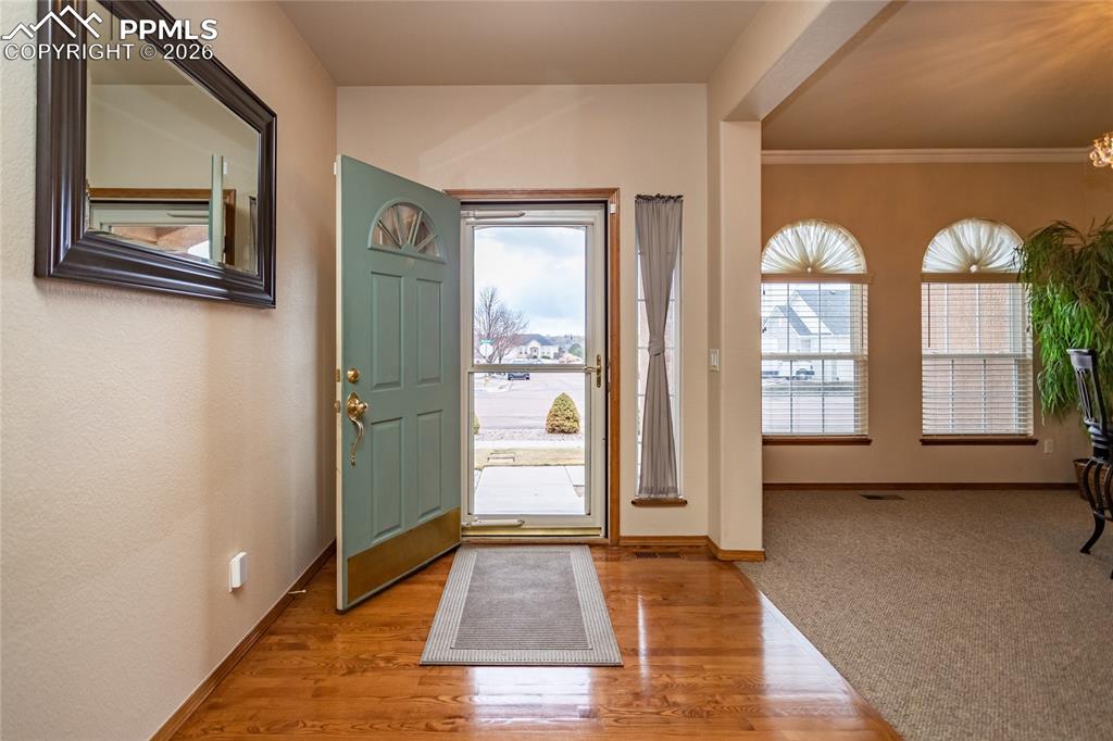 Another view of the foyer featuring storm door.