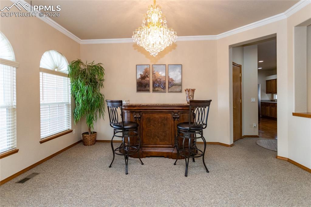 Spacious dining room with crown molding and beautiful crystal chandelier.