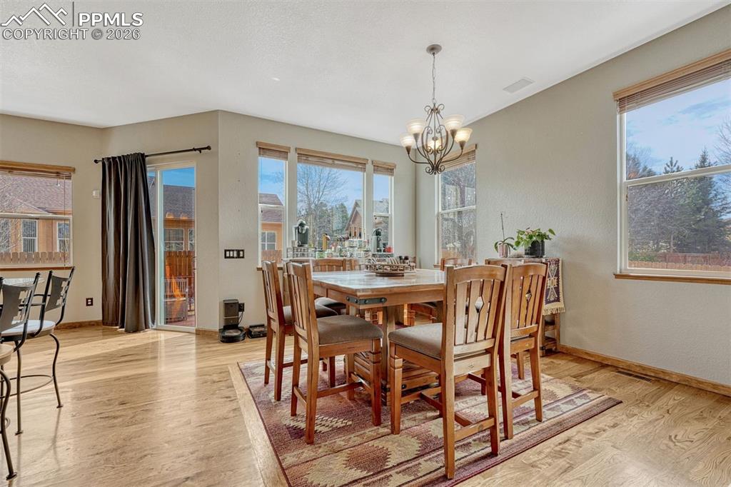 Dining room featuring hanging lights, healthy amount of natural light, and  wood flooring