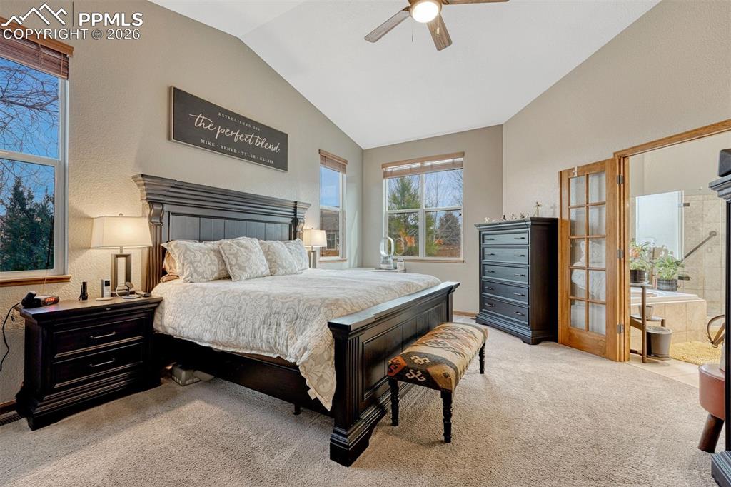 Bedroom featuring light colored carpet, a ceiling fan, and lofted ceiling