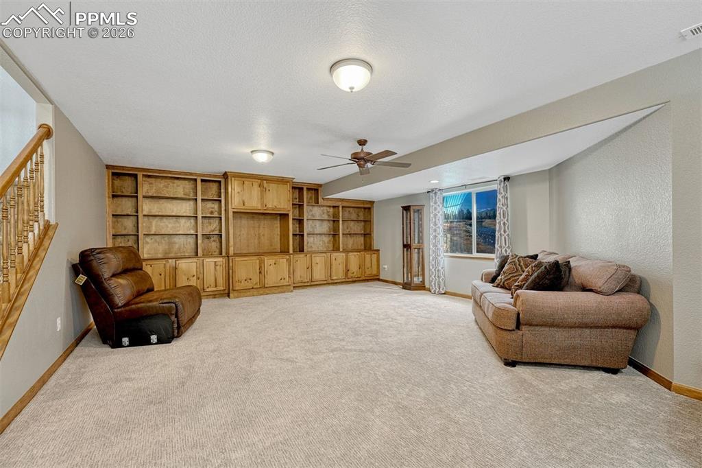 Basement 2nd family/rec room  featuring ceiling fan, light colored carpet, and a textured wall