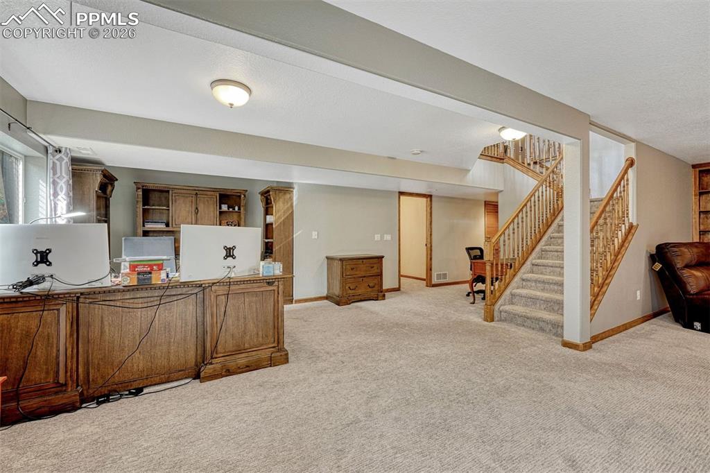 Office space featuring light colored carpet and a textured ceiling