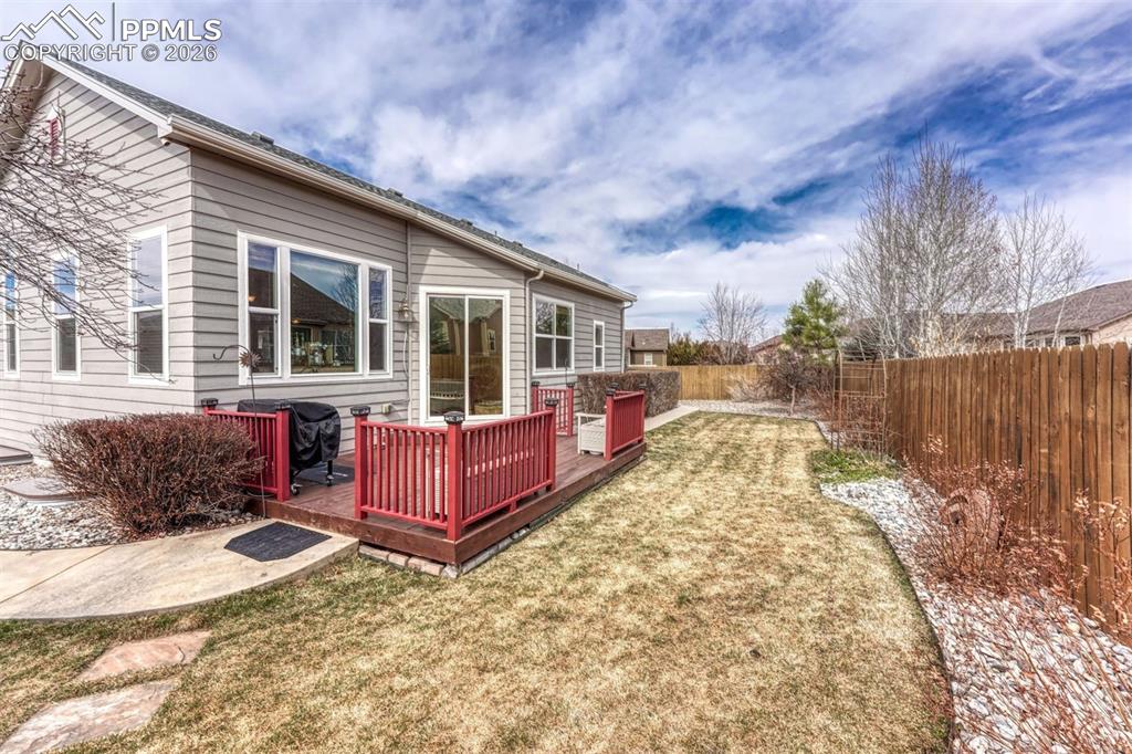 Rear view of property featuring a fenced backyard and a deck