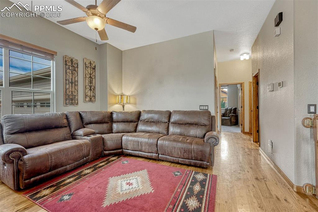 Living area with wood floors and a ceiling fan