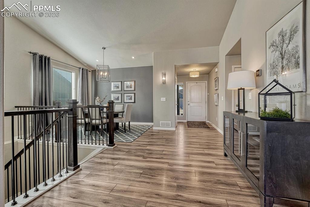 View of the Front Entry and Formal Dining Room with iron rails to the Finished Basement.