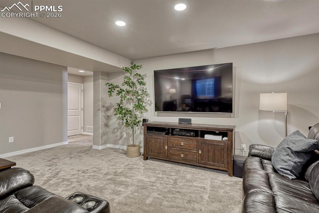 Spacious Family Rec Room with neutral carpet and space for a TV area, game area, and work/study space.