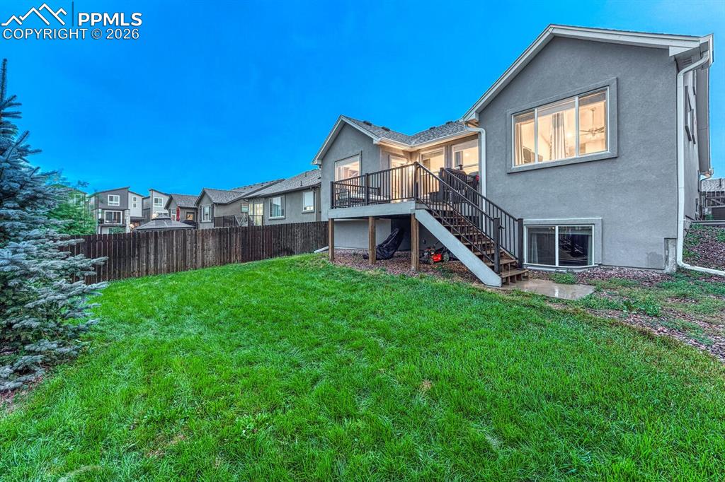 Rear view of house and fenced backyard.