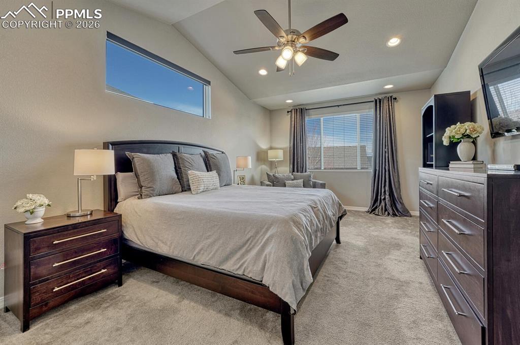 The Primary Suite offers a private retreat with neutral carpet, a lighted ceiling fan, recessed lighting, large view windows, walk in closet, and spa like shower bathroom.