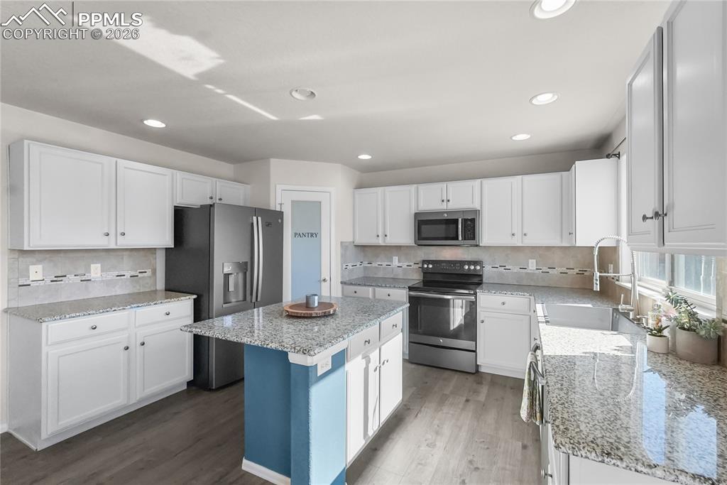 Kitchen with granite countertops, island and pantry.