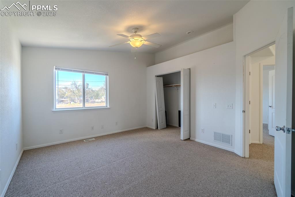 Unfurnished bedroom featuring carpet floors, a ceiling fan, and a closet