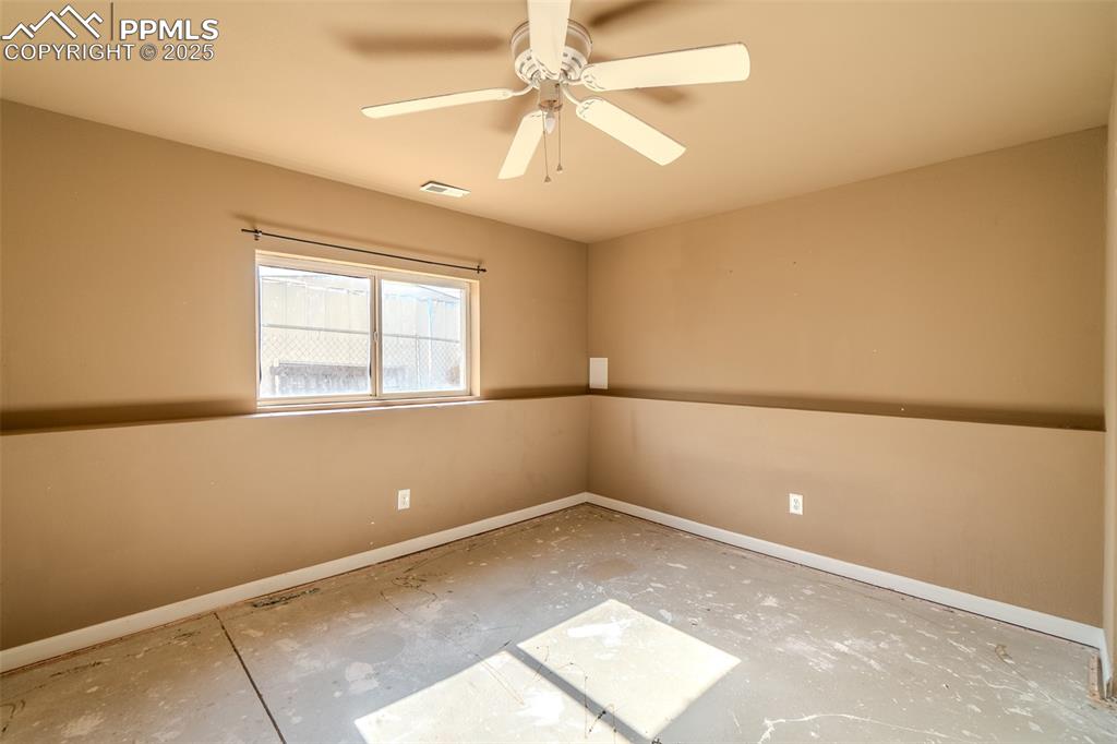 Empty room featuring baseboards and ceiling fan