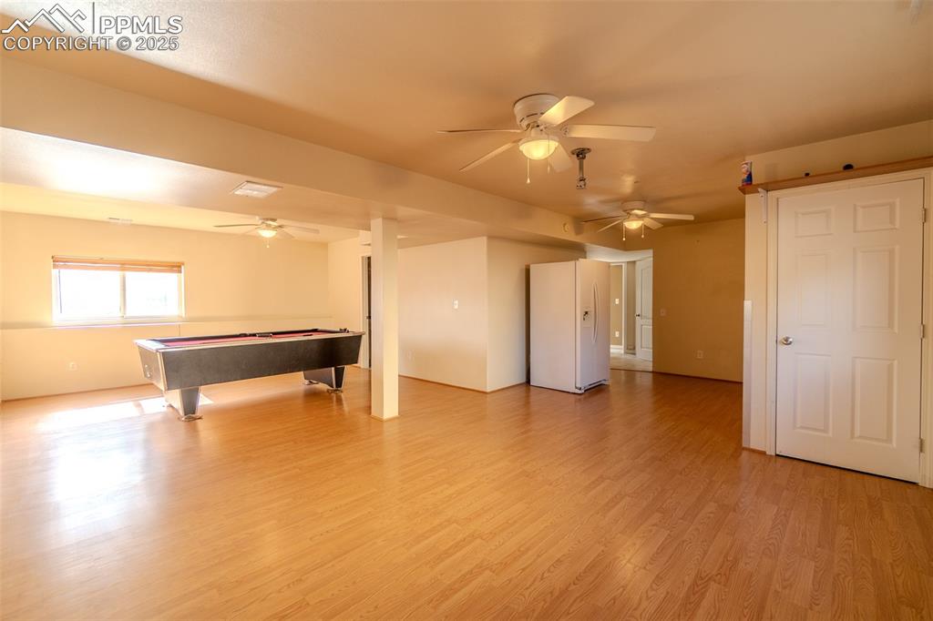 Playroom with light wood-style floors, a ceiling fan, and billiards table