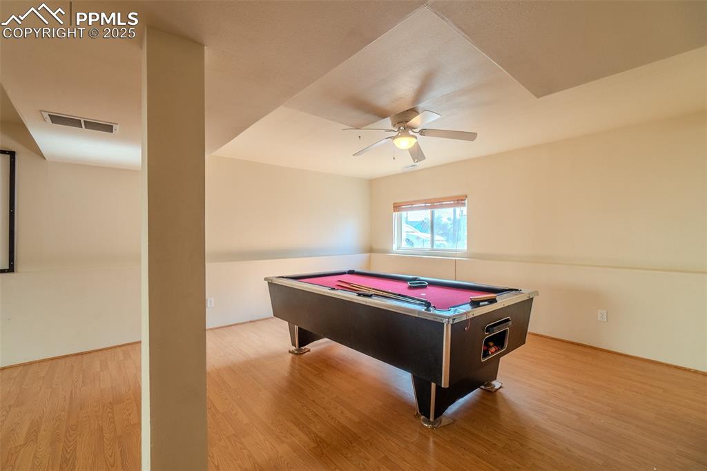 Rec room featuring billiards table, light wood finished floors, and ceiling fan