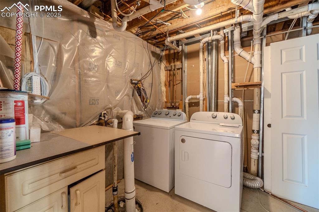 Laundry room with concrete flooring and washing machine and clothes dryer